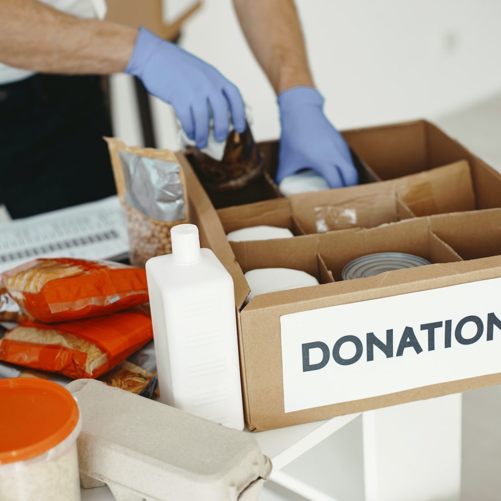 Volunteer guy packs boxes with a humanitarian help